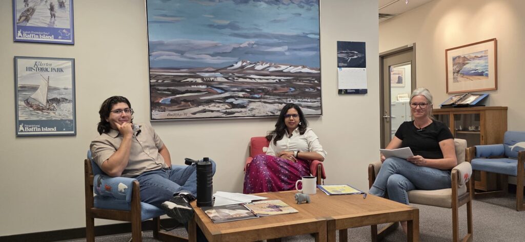 Three people sitting around a coffee table in an office